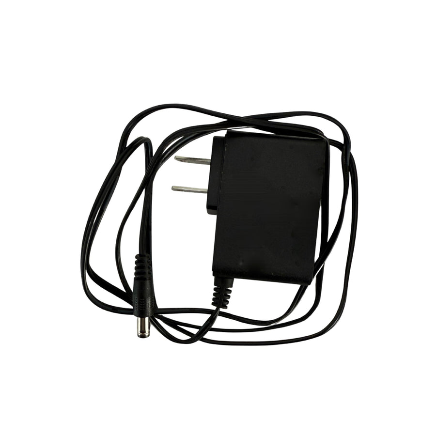 Black power adapter with coiled cable on a white background